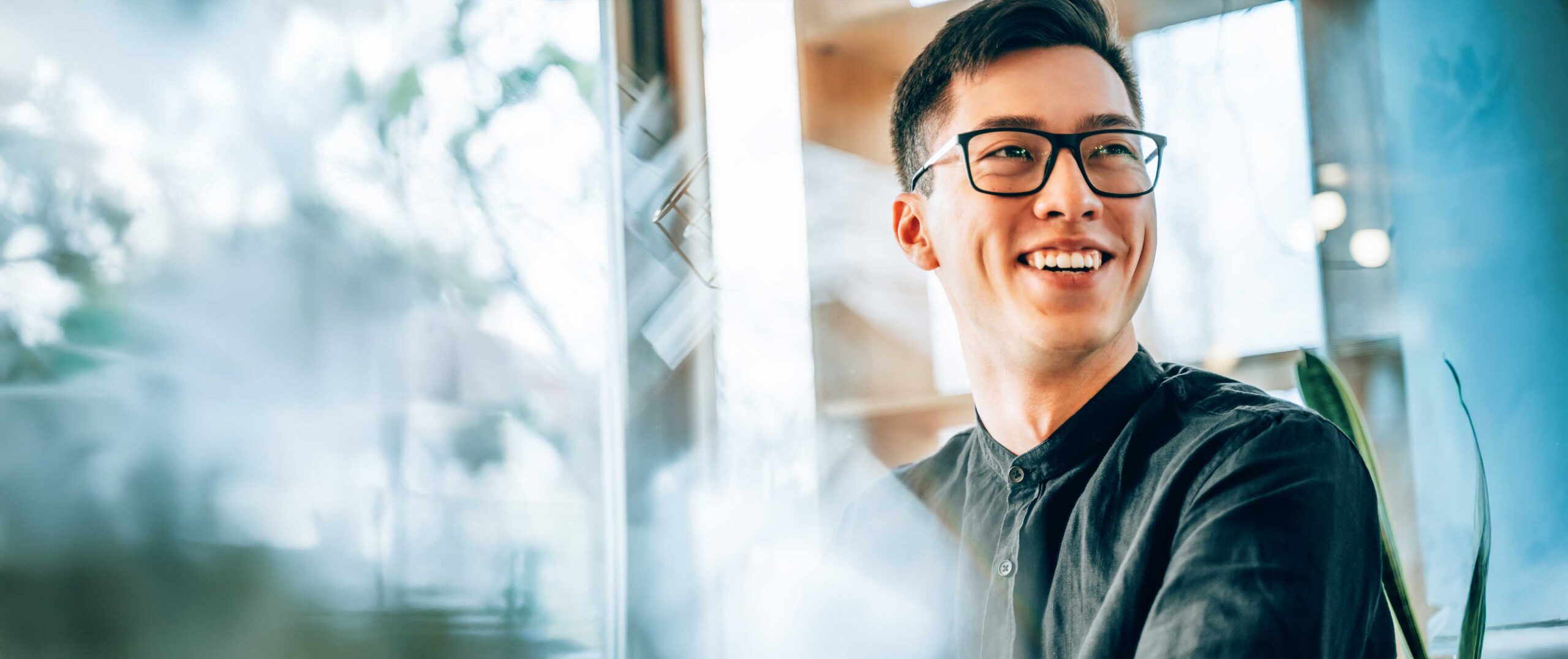 Man glasses smiling to his left.
